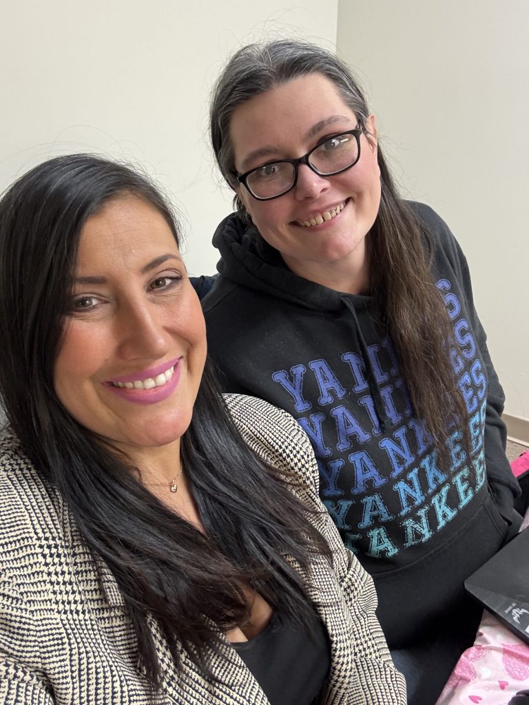 Selfie photo of two dark-haired women smiling at the camera